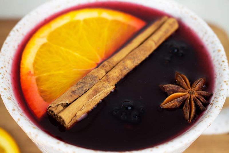 Non alcoholic mulled wine served in a mug with orange and mulling spices