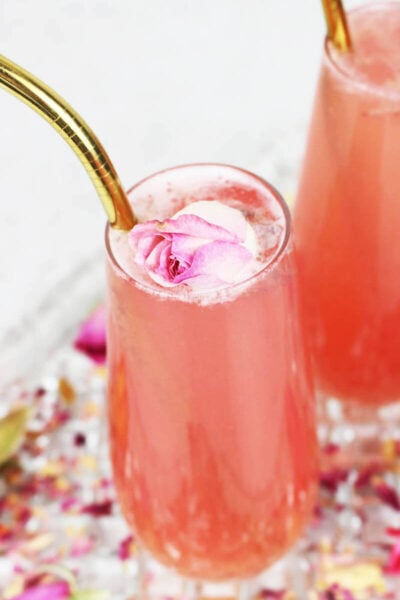 pink lemonade garnished with dried roses and a gold straw.