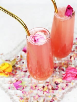 pink sparkling drink with a gold straw and baby pink flower garnish