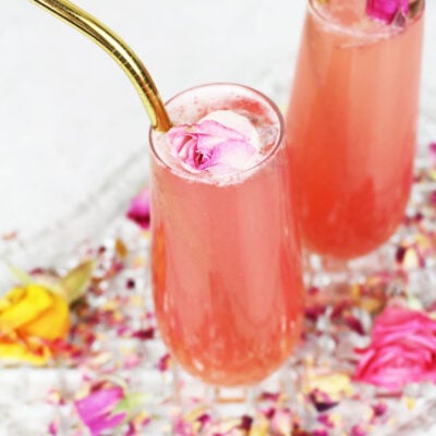 pink sparkling drink with a gold straw and baby pink flower garnish