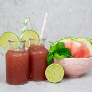 watermelon mocktails garnished with lime wheels and pink and green striped straws
