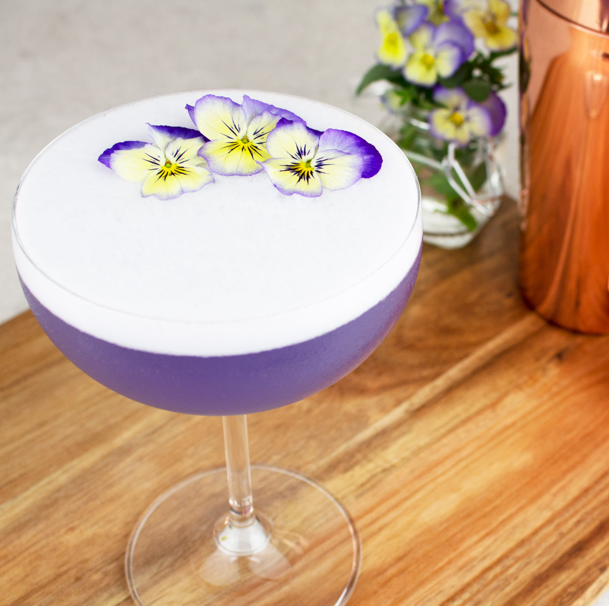 purple mocktail with edible flowers on top