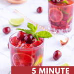 cherry mocktails in 2 glasses garnished with mint and cherries, with scattered limes