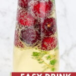 champagne glass with an easy garnish of frozen cherries and time for christmas