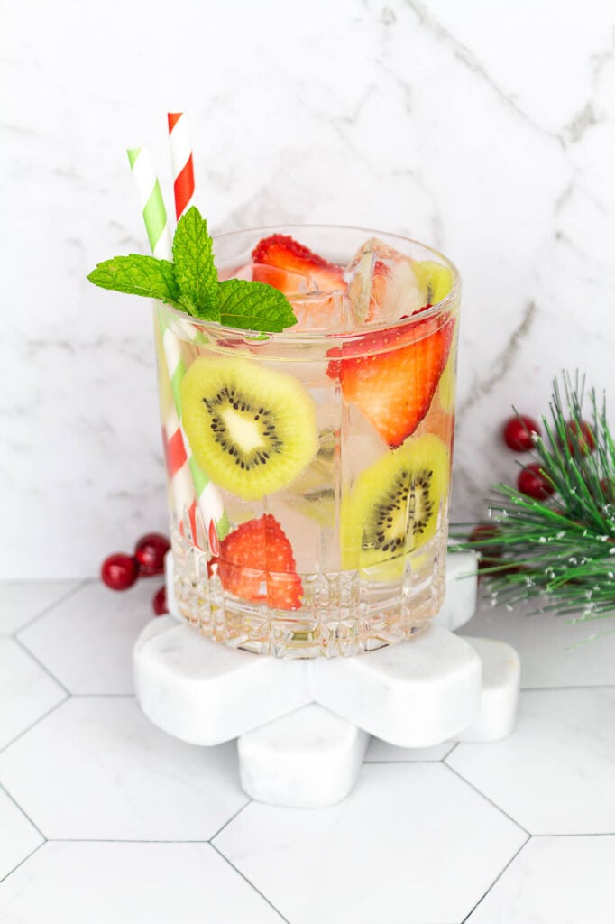 kiwi strawberry drink with ice and sparkling water with 2 red and green straws