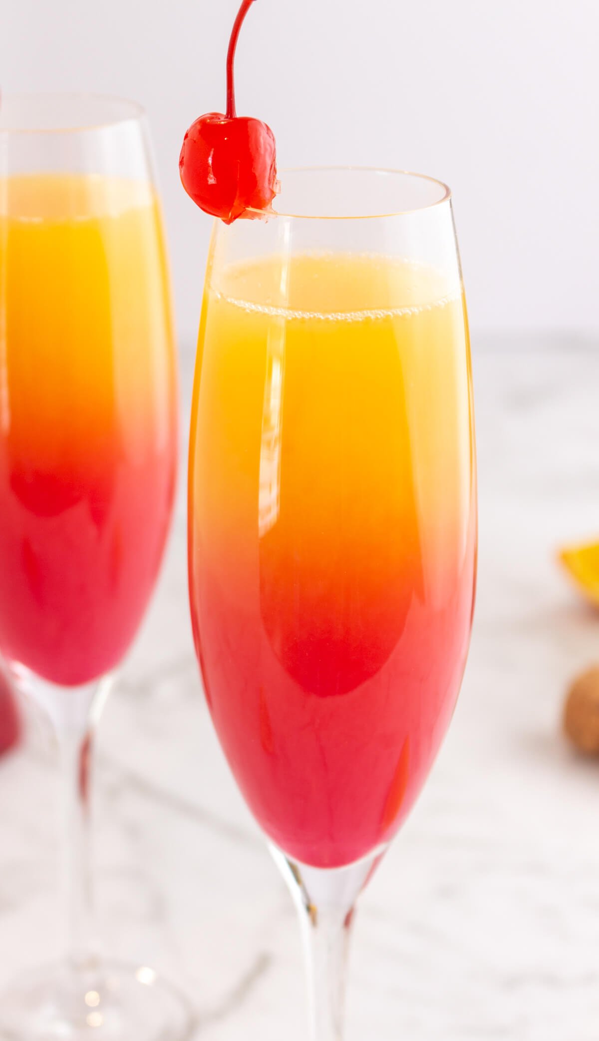 sunset mocktail in a champagne glass with red at the bottom gradually turning into orange then yellow at the top.