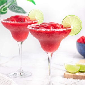 2 virgin raspberry margaritas with salt rims and lime wheel