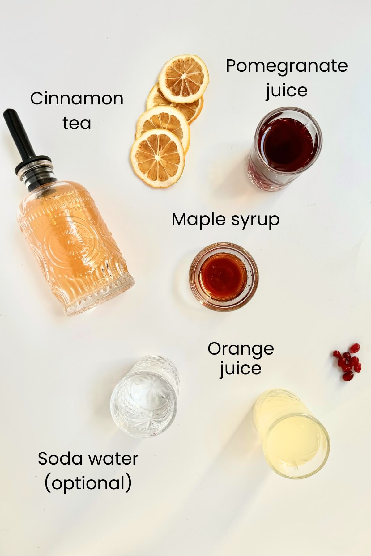 ingredient shot with elements needs to make the recipe including cinnamon tea maple syrup lemon juice soda water and pomegranate juice