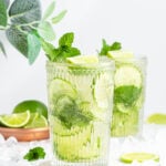 large tall glass with non-alcoholic mojito inside garnished with mint and lime.