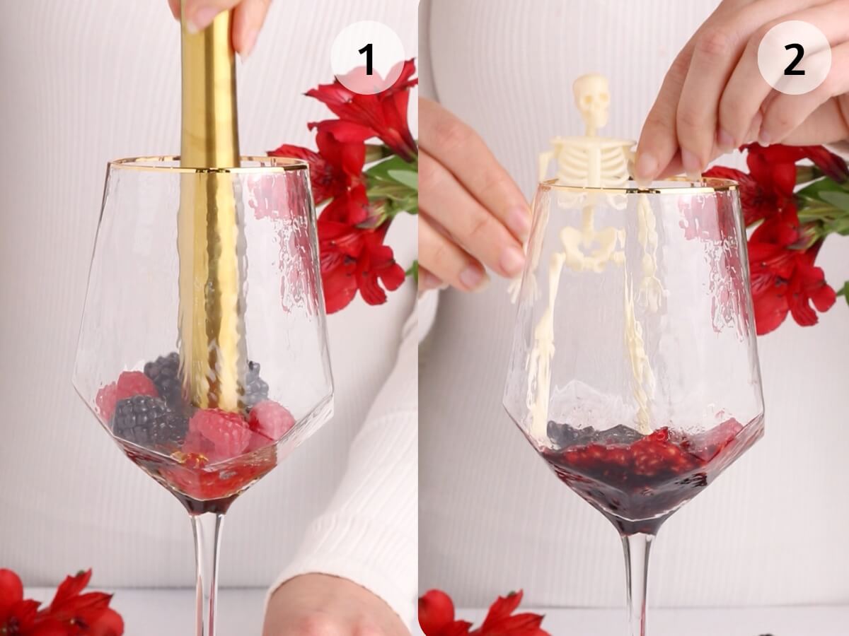 Split image: Left side shows a hand using a gold muddler to crush berries in a wine glass. Right side shows a hand lowering a small skeleton figure into the same glass. Red flowers are in the background.