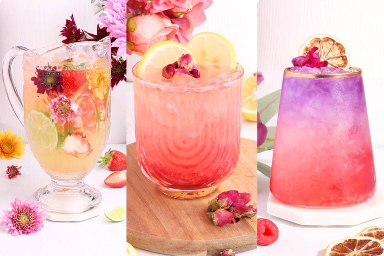 Three colorful, floral-mocktails drinks in decorative glasses, garnished with flowers, lemon slices, and fruit, displayed against a light background with scattered flowers and fruit for a bright, fresh presentation.