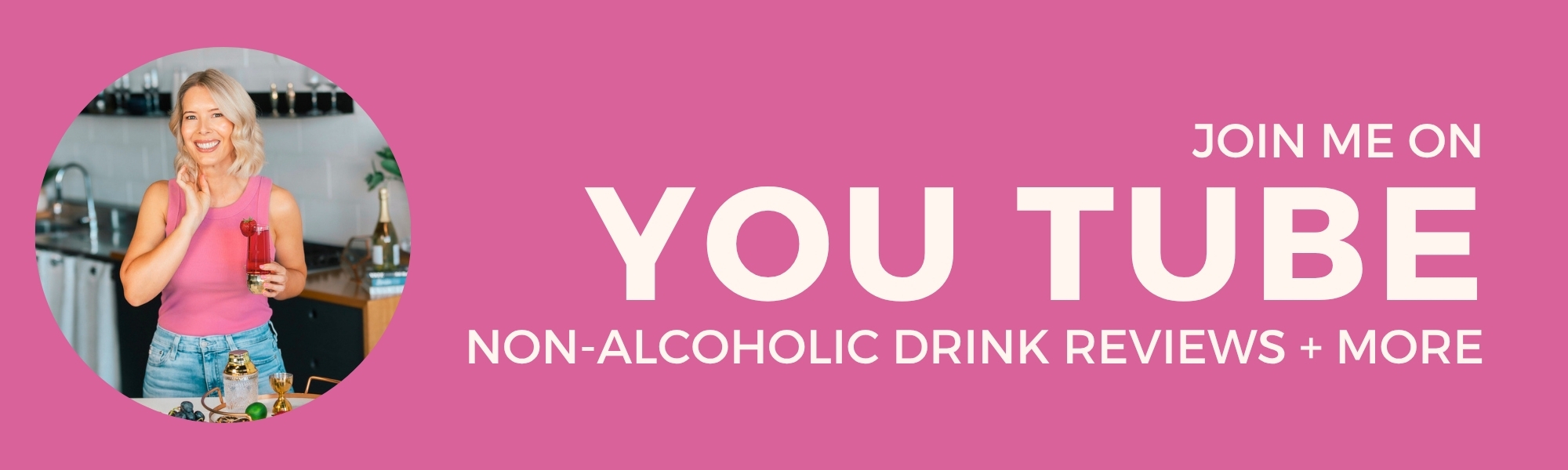 A smiling woman in a pink top holds a drink in a kitchen. Text: Join me on YouTube. Non-alcoholic drink reviews + more. Pink background.
