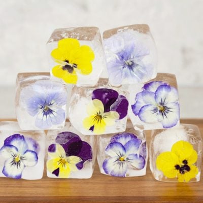 ice-blocks-flowers frozen ice cubes with a mix of purple and yellow viola flowers inside, stacked to form a pyramid shape