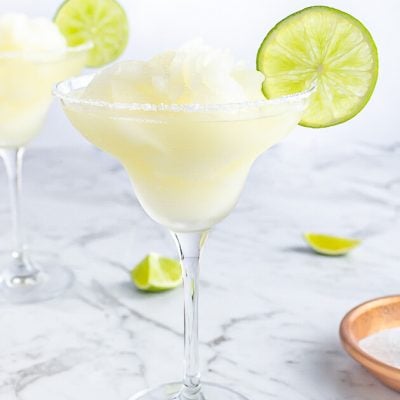 margarita mocktail in a classic glass with a salt rim and lime wheel for garnish
